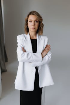 Professional portrait of a woman in a white suit, conveying confidence and elegance.